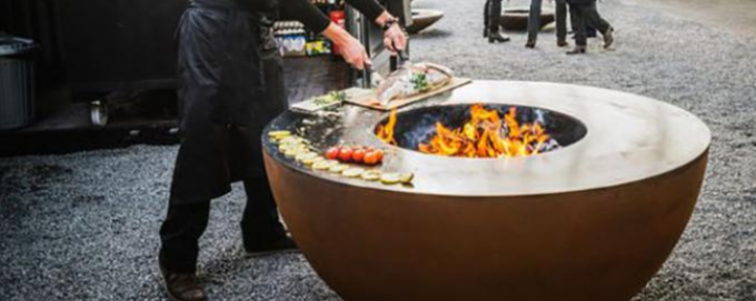 Cortenの鋼鉄火ピットBBQのグリルを燃やす屋外の調理木