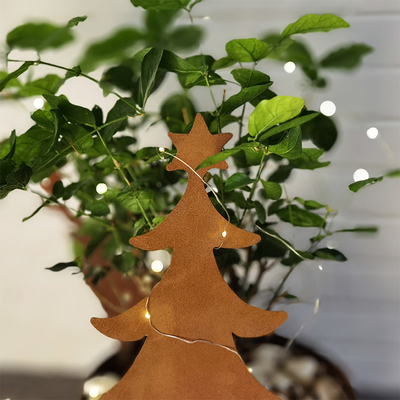 Cortenの鋼鉄錆つかせた金属の庭はクリスマス ツリーの定形装飾を飾る