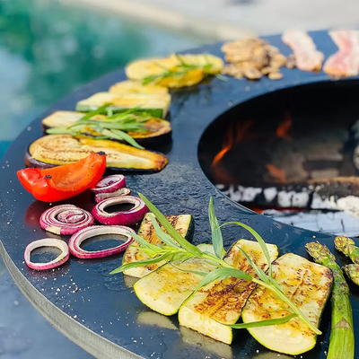 金属の庭のCortenの鋼鉄屋外のBBQの木炭のグリルの前にさびた
